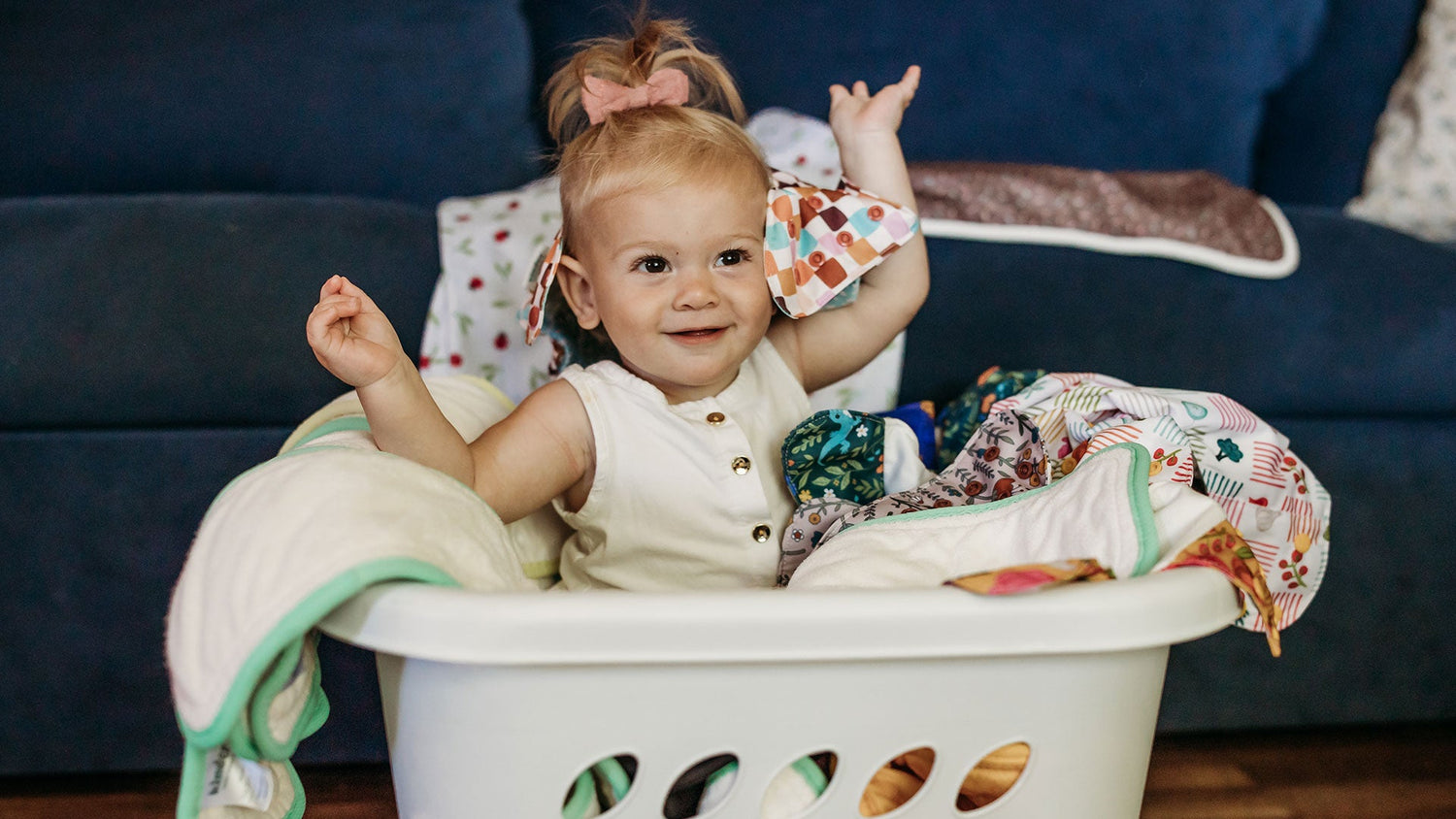 baby sitting in pile of clean cloth diapers learn about stripping and sanitizing cloth diapers